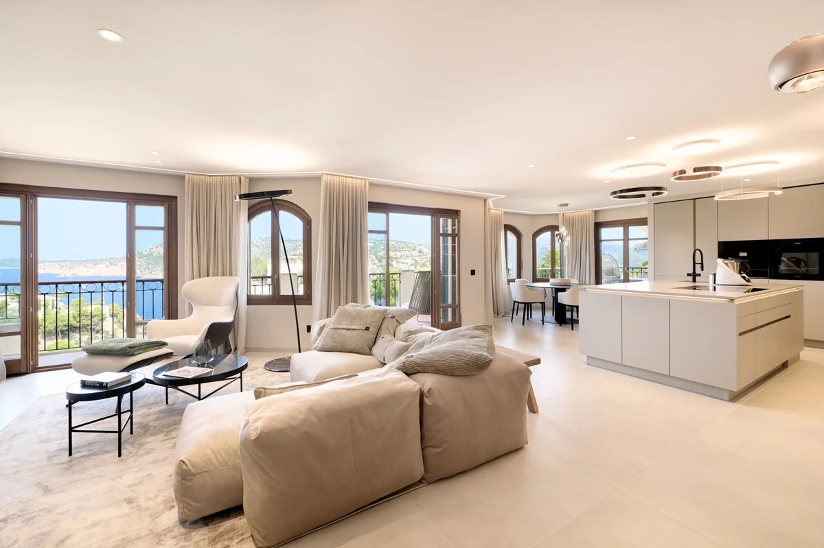 Furnished living room with sculptural seating, natural textures and tall windows